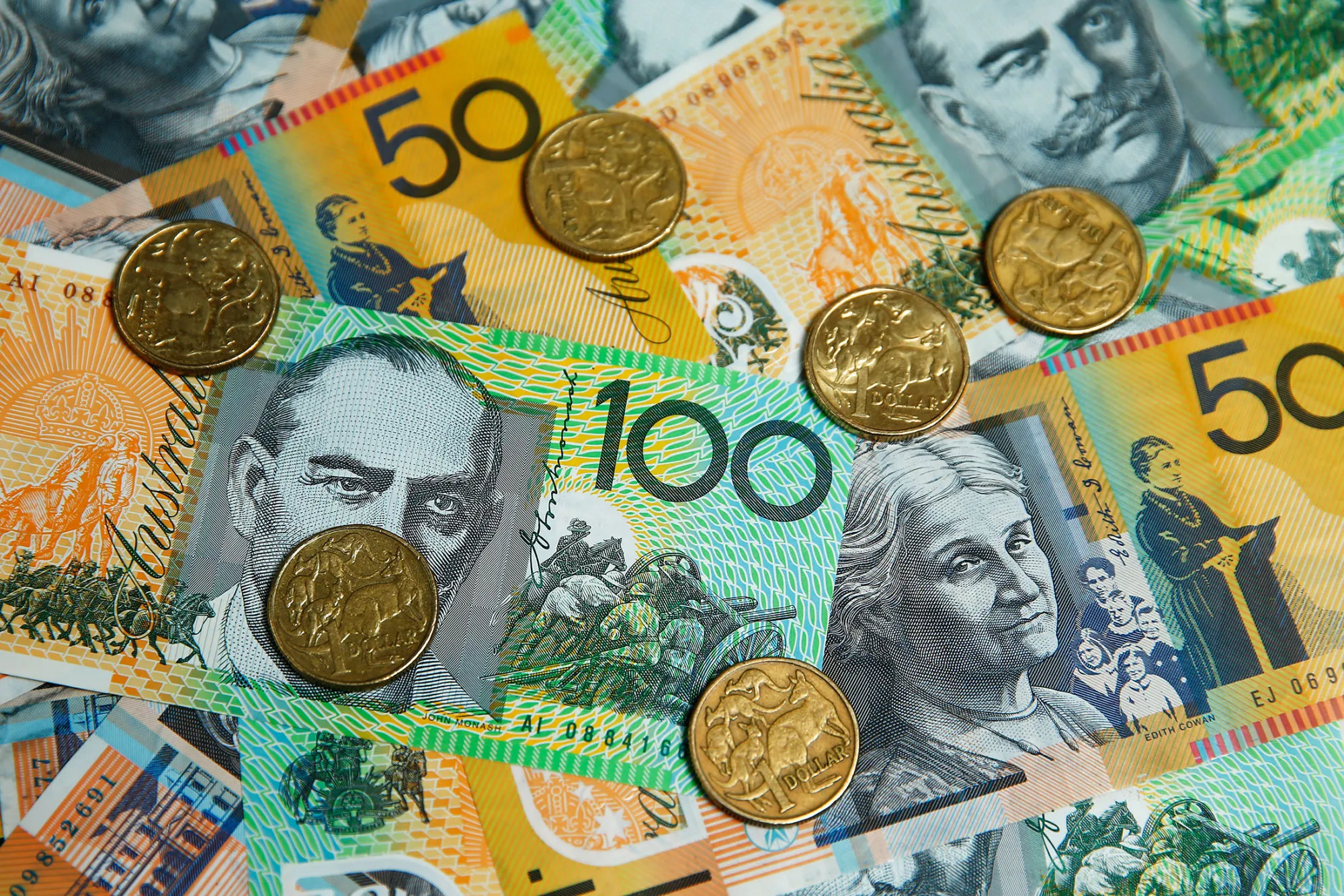 Australian one-dollar coins, one-hundred dollar and fifty dollar banknotes are arranged for a photograph in Sydney, Australia, on July 4, 2016.
