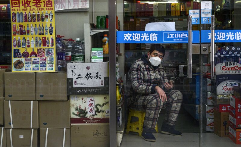 Un uomo attende i clienti nel suo negozio a Pechino il 25 febbraio.
