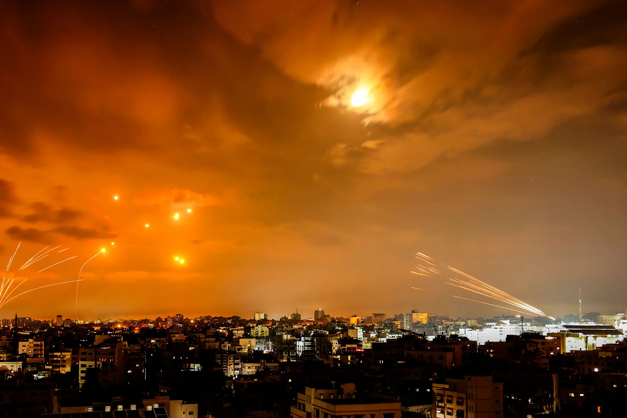 Rockets fired from Gaza, right, intercepted by the Israeli Iron Dome missile system.