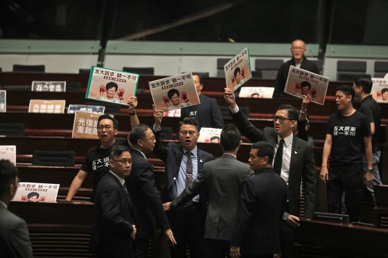 Lam’s Escape From Rowdy Hong Kong LegCo Shows Policy Gridlock