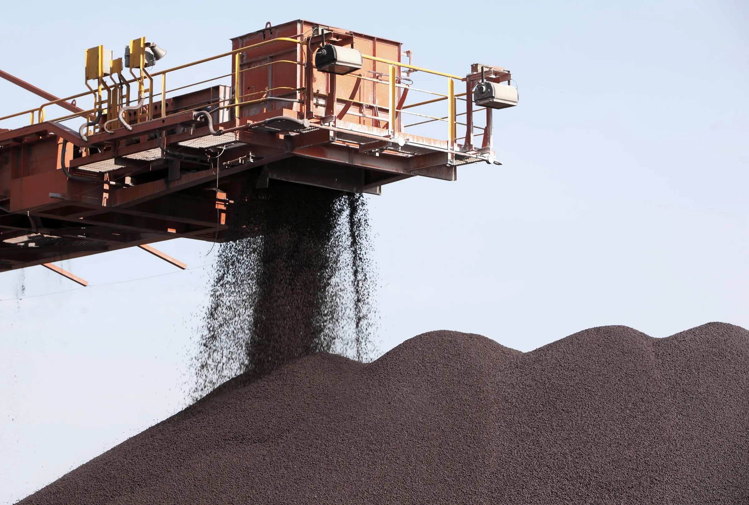 A conveyer belt dumps iron ore into a pile at the Shanghai International Port Group in Shanghai, China.