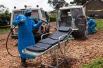 Red Cross workers clean ambulances prior to transporting Ebola victims to a hospital in Mubende on Oct. 13.