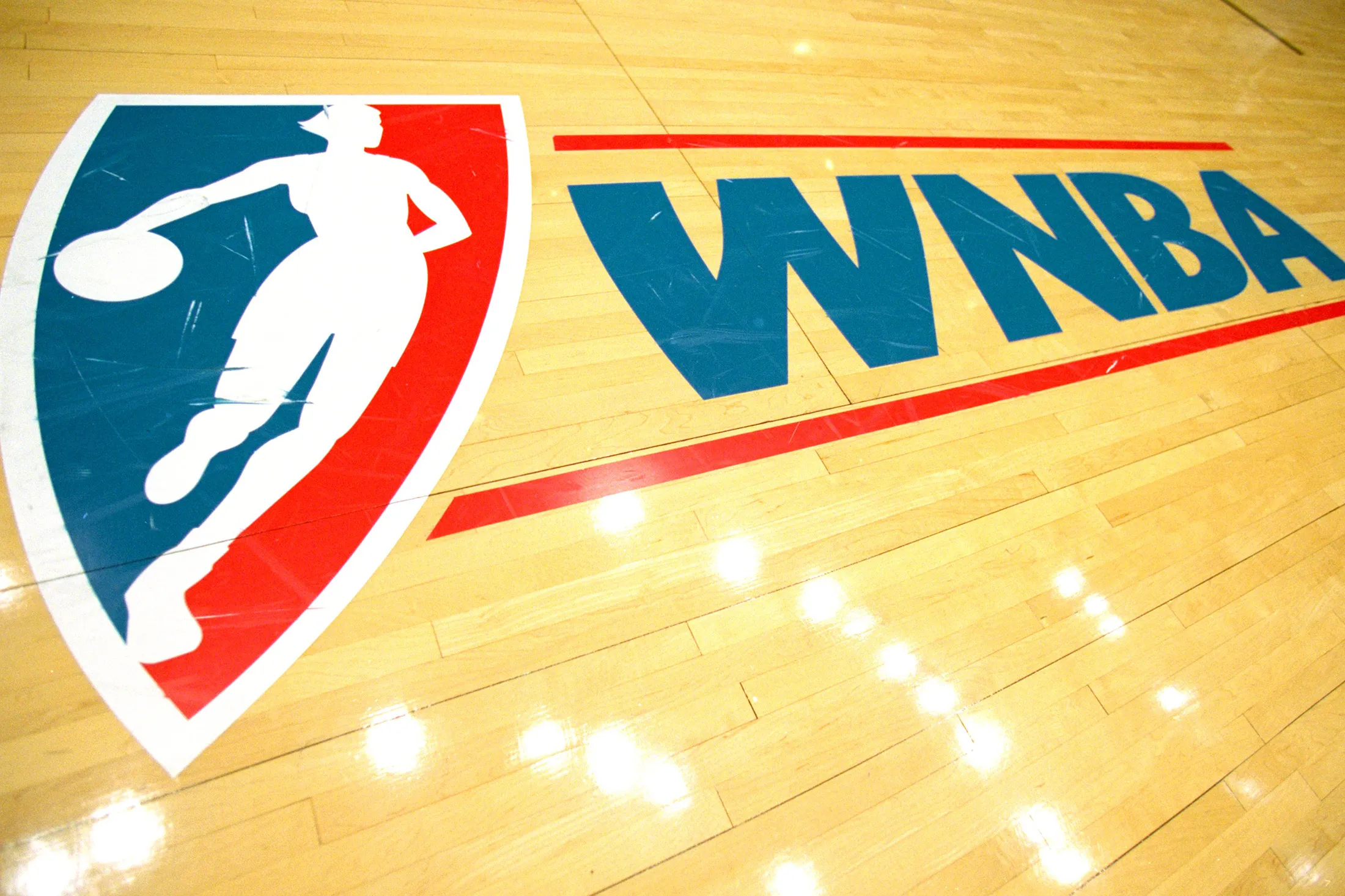 The WNBA Logo on the basketball court.