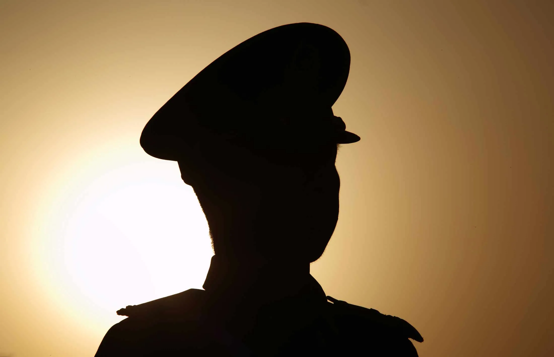 The sun rises behind a paramilitary police officer standing guard outside Tiananmen Square ahead of the closing session of the third session of the 12th National People's Congress (NPC) in Beijing, China, on Sunday, March 15, 2015.
