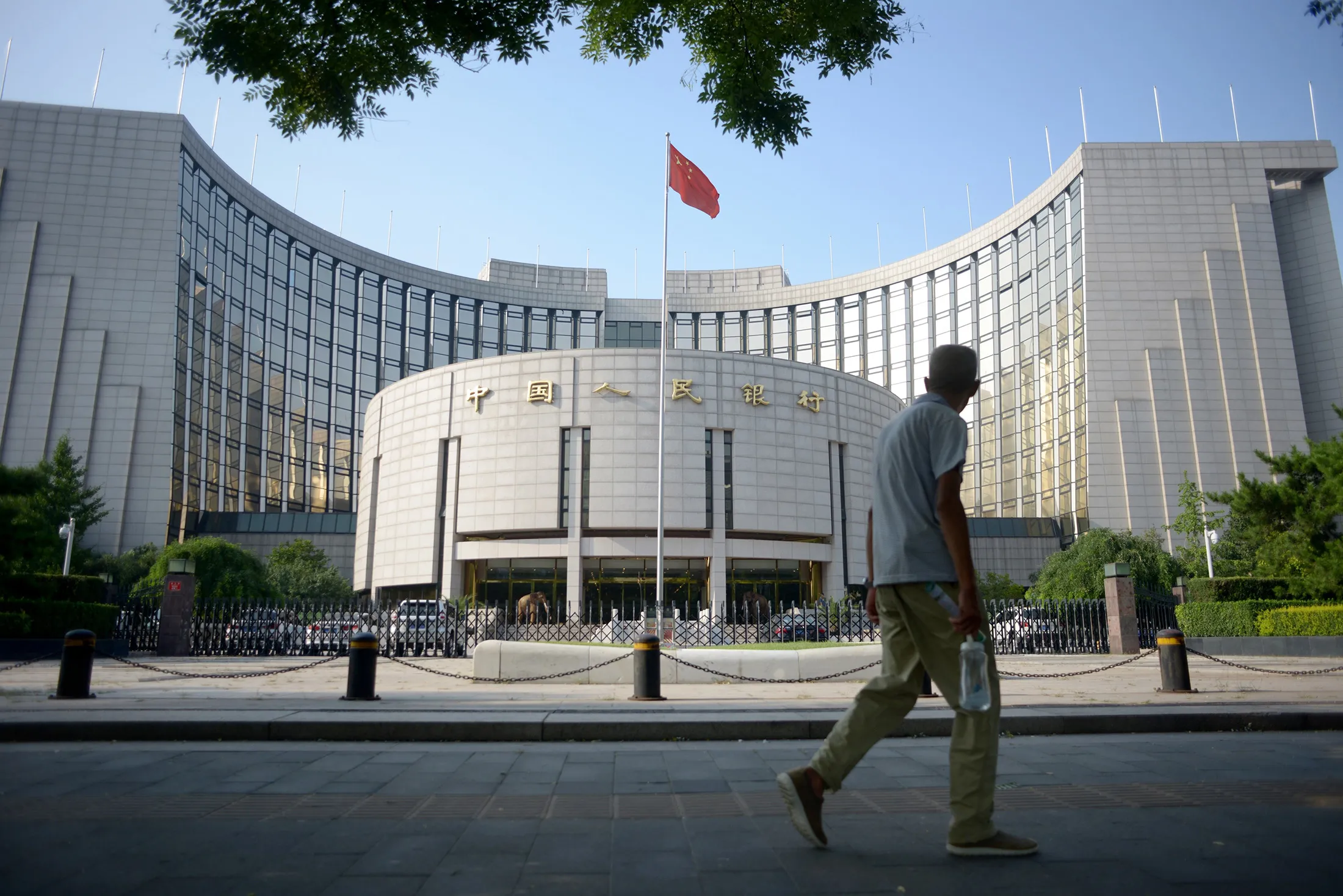 An elderly man walks past the People's Bank of China in Beijing on Aug. 12.
