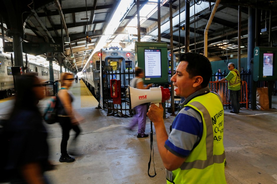 A New Jersey Transit member gives instructions to people as they commute to New York at the Hoboken Terminal in New Jersey.