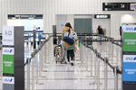 A passenger pushes luggage through a departures hall of Narita Airport in Narita, Chiba Prefecture, Japan.