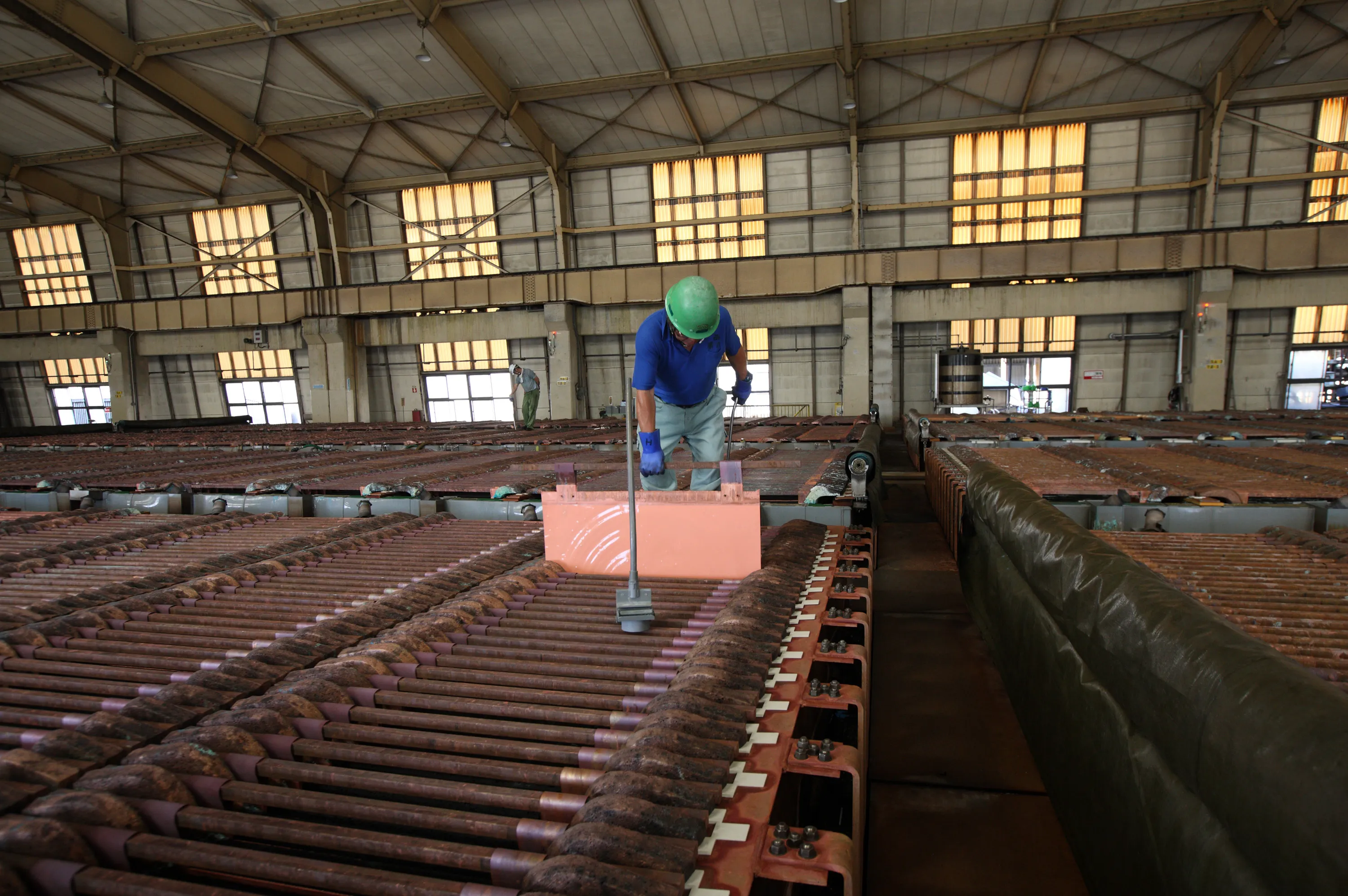 A worker checks a sheet of electrolytic copper in a tankhouse at the Onahama Smelting & Refining Co. plant in Iwaki City, Fukushima Prefecture, Japan. Photographer: Tomohiro Ohsumi/Bloomberg