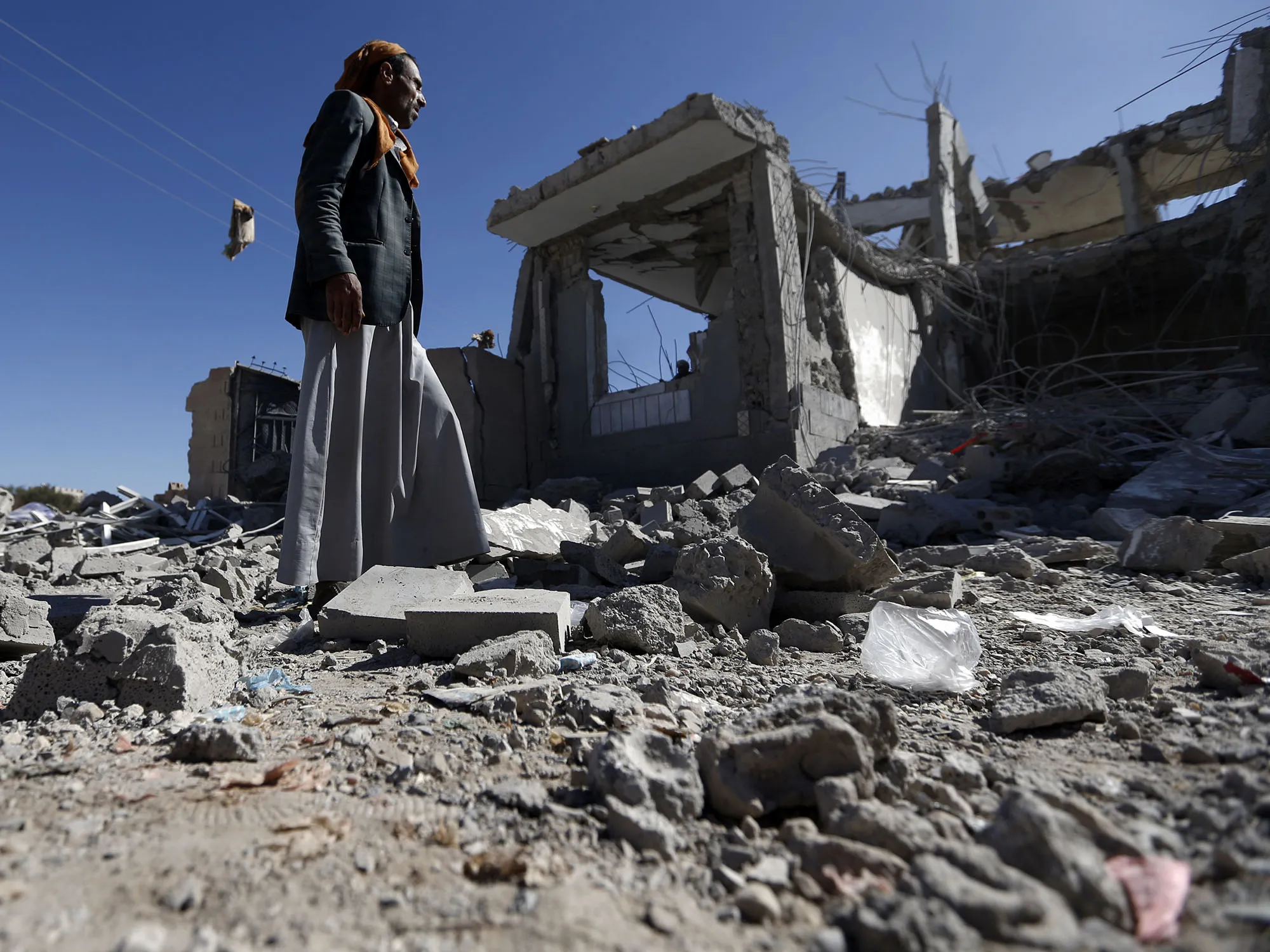 A man&nbsp;checks a&nbsp;damaged building in the aftermath of a reported air strike in the Yemeni capital of Sanaa on March 8, 2018.