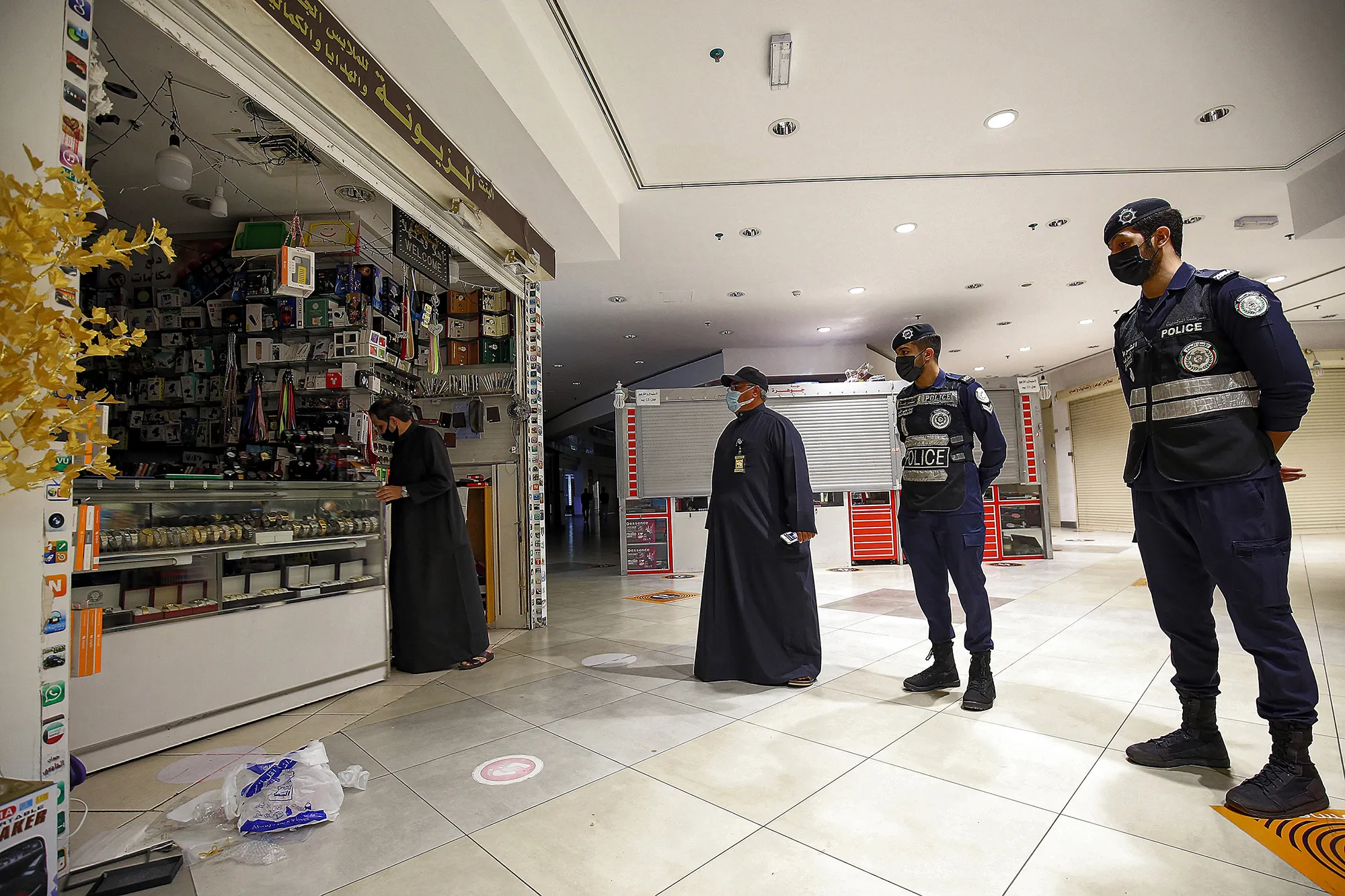 Policemen enforce the early closure of shops at a mall in accordance with government-imposed Coivd-19&nbsp;restrictions in Kuwait City on Feb.&nbsp;10.