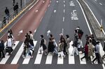 Pedestrians cross a street in Tokyo's Shinjuku area on April 13, 2021, as the city reported 510 new Covid-19 coronavirus infections. (Photo by Charly TRIBALLEAU / AFP) (Photo by CHARLY TRIBALLEAU/AFP via Getty Images)