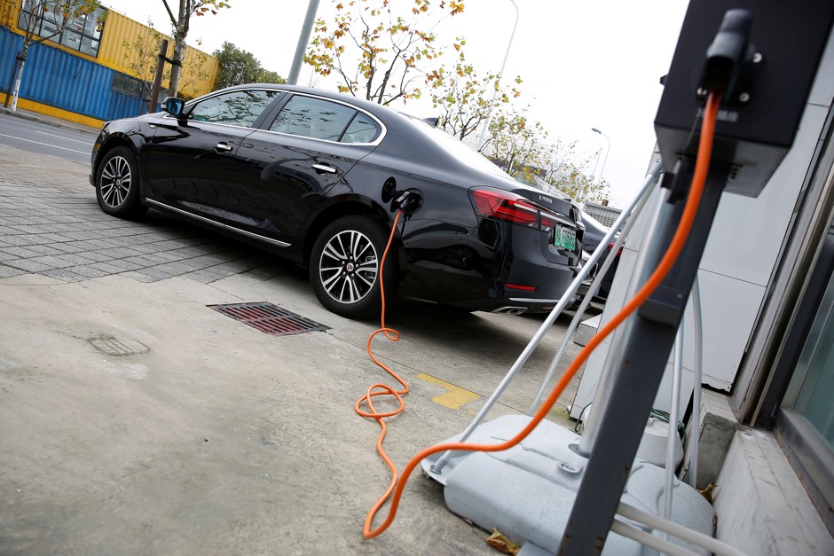 A Roewe 950 hybrid electric car is displayed with its plug-in charger at an electric car dealership in Shanghai.