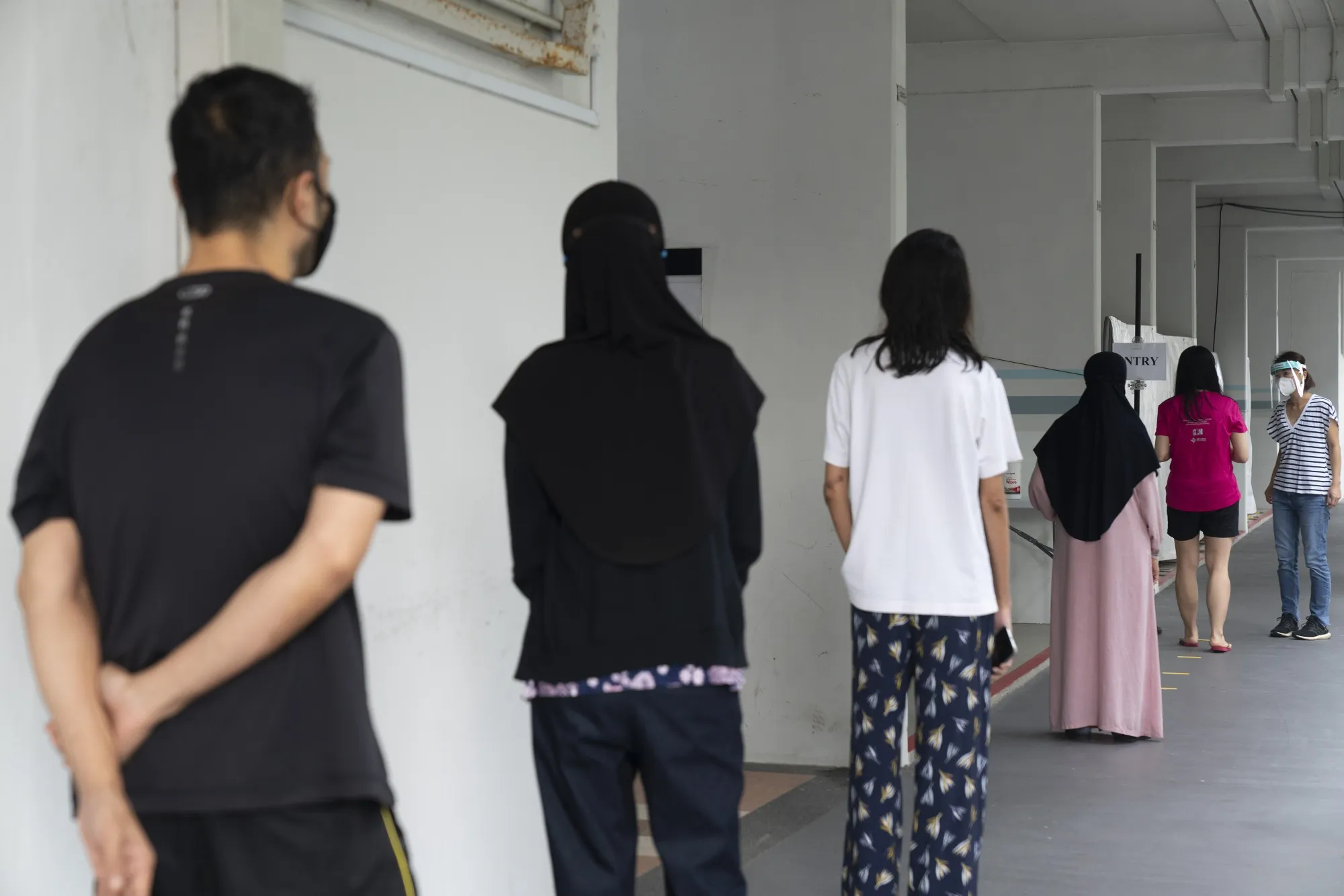 People stand in line outside a Covid-19 test site&nbsp;in the Hougang district of Singapore in May.