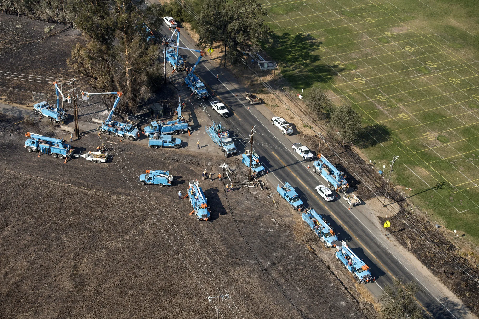 PG&E employees work to fix downed power lines burned by wildfires in California on Oct. 12