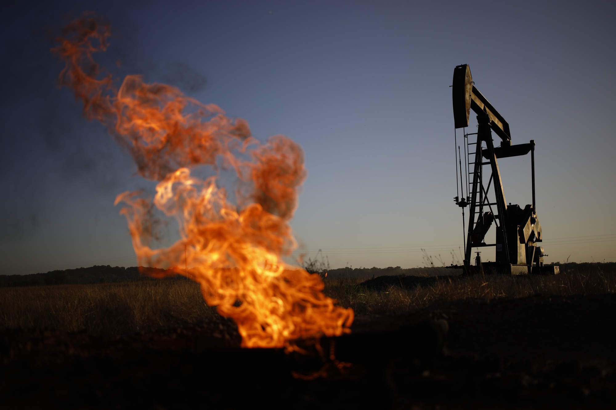 A natural gas flare burns near an oil pump jack. Subsidies for fossil fuels have risen over the past two years despite nations’ commitments to phasing them out and reducing emissions.
