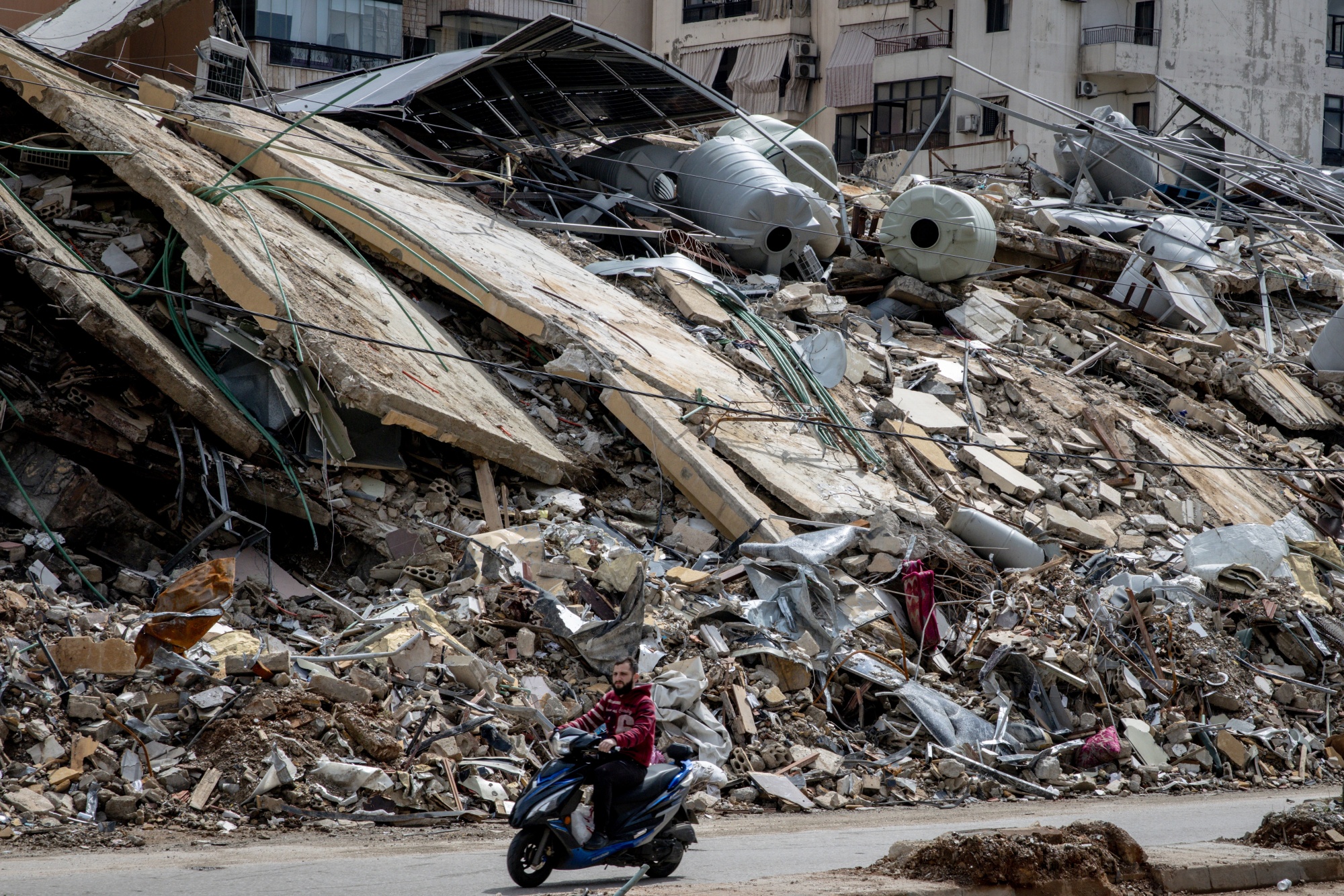 BEIRUT, LEBANON - MARCH 28: A motorbike passes by a building destroyed by an Israeli strike in the Dahyeh neighbourhood on March 28, 2026 in Beirut, Lebanon. Israel has continued its aerial and ground assault in Lebanon after Hezbollah, the Iran-backed militant group in Lebanon, launched missiles at Israel in what it said was retaliation for the joint U.S.-Israeli war on Iran. (Photo by Chris McGrath/Getty Images)