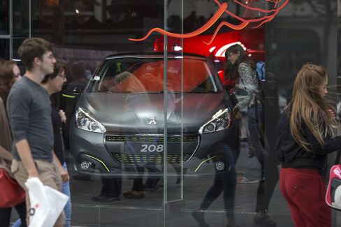 A Peugeot 208 automobile sits in a showroom in Paris.