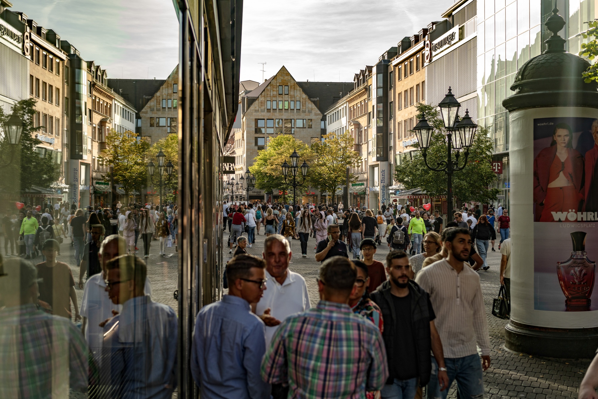 Shoppers walk along a pedestrianized shopping street in Nuremberg, Germany.