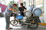 An attendant fills a customer's scooter with gasoline at a Formosa Petrochemical gas station in Taipei.