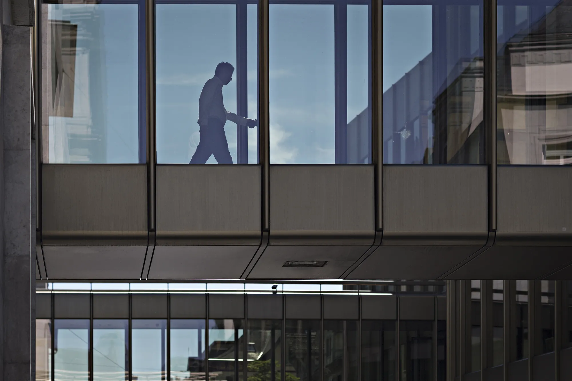 A worker walks across a bridge inside a UBS Group AG office building in Zurich, Switzerland, on Thursday, July 6, 2017.&nbsp;