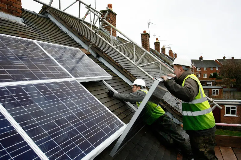 Workers fit solar panels in Wrexham, Wales.
