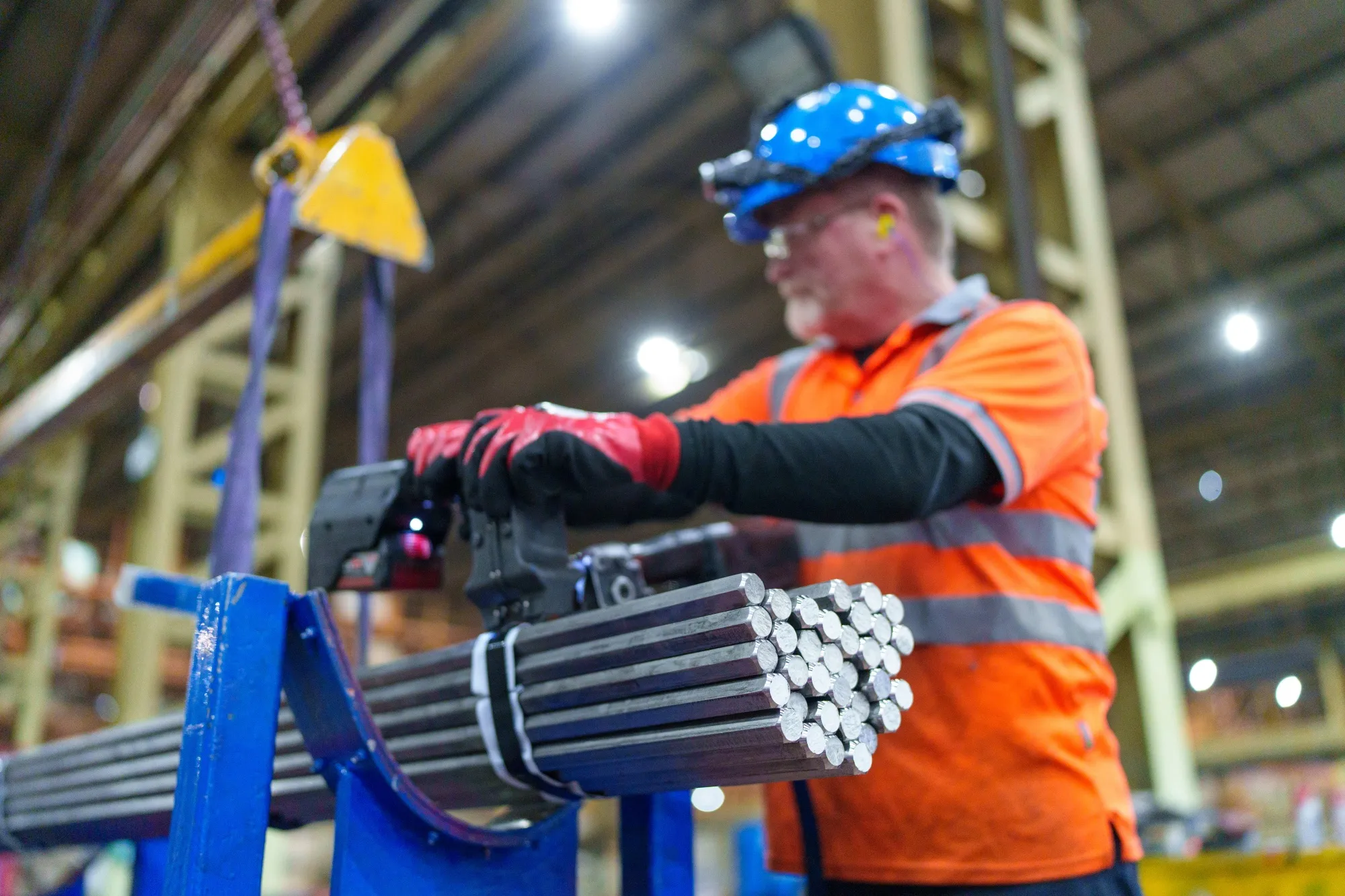 A worker prepares to wrap cold drawn stainless steel bars at a factory in Sheffield.
