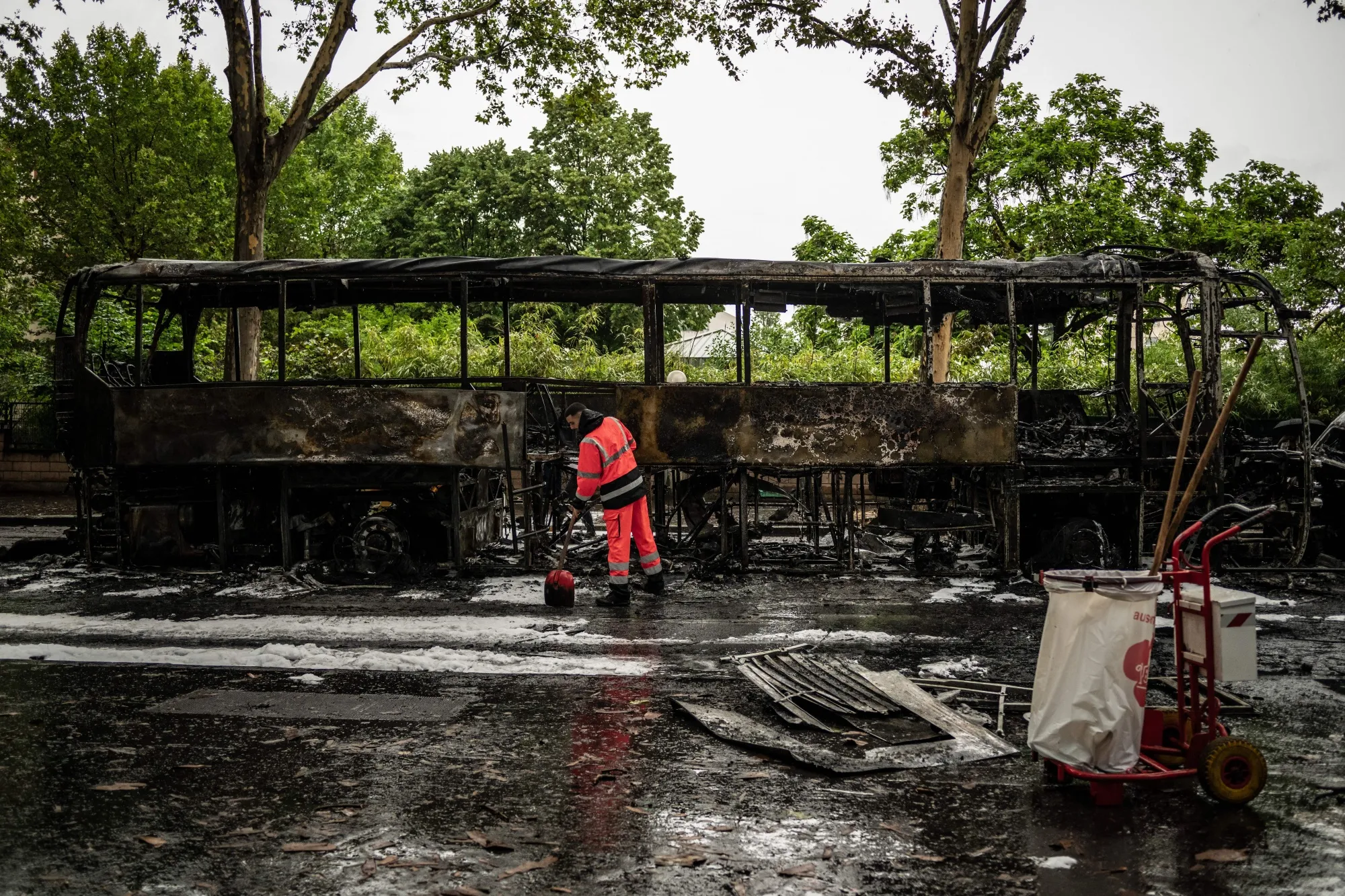 A municipal worker cleans near a burned out bus following protests in Lyon, France.