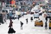 A woman wearing a mask crosses the street in Times Square in Manhattan on March 17, 2020 in New York City.