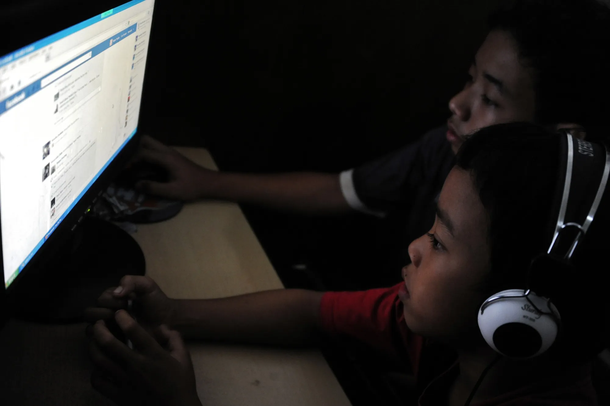 Indonesian children look at Facebook in an internet shop in Bali.