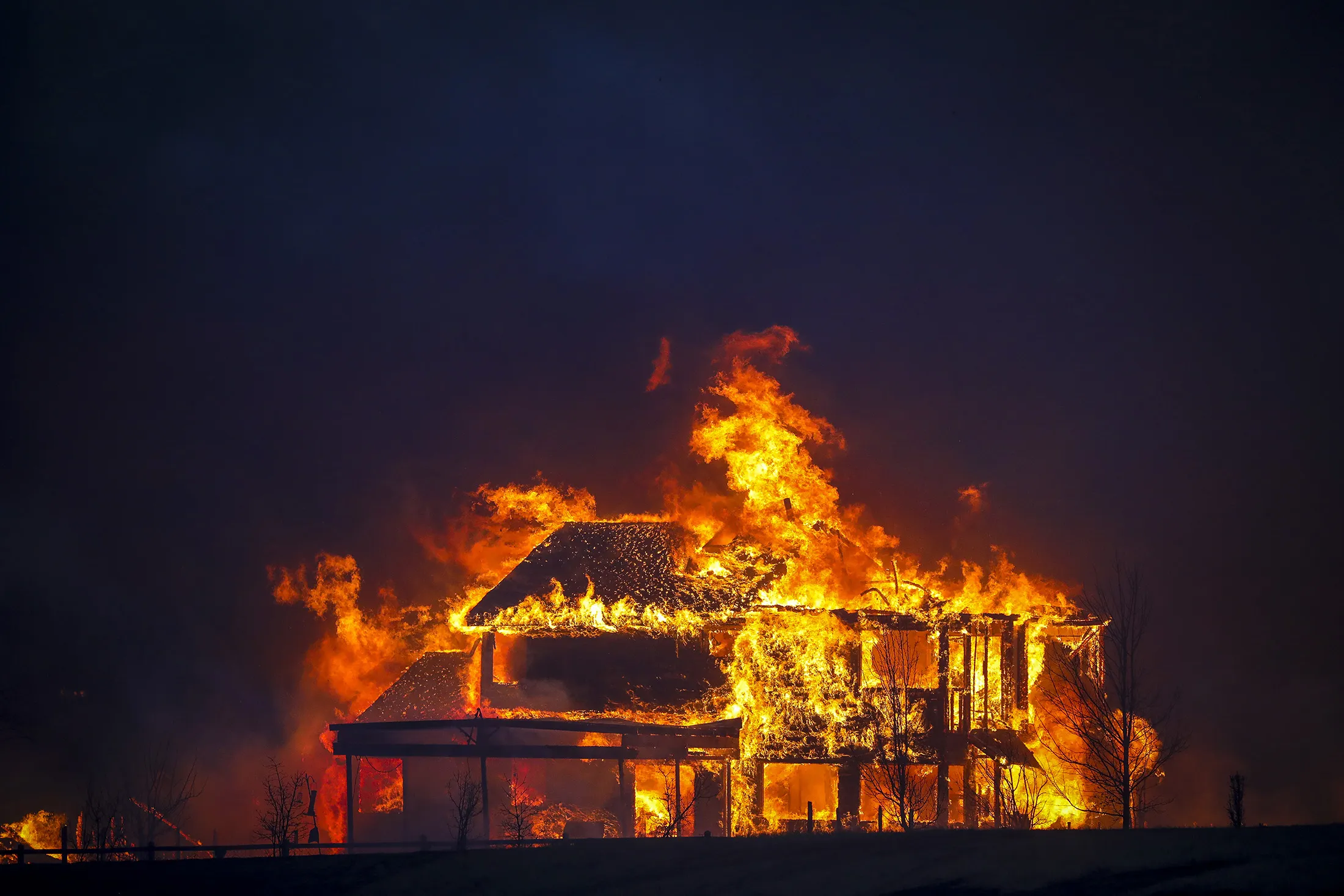 A home burns after a fast-moving wildfire swept through the area in Louisville, Colorado, on December 30, 2021.