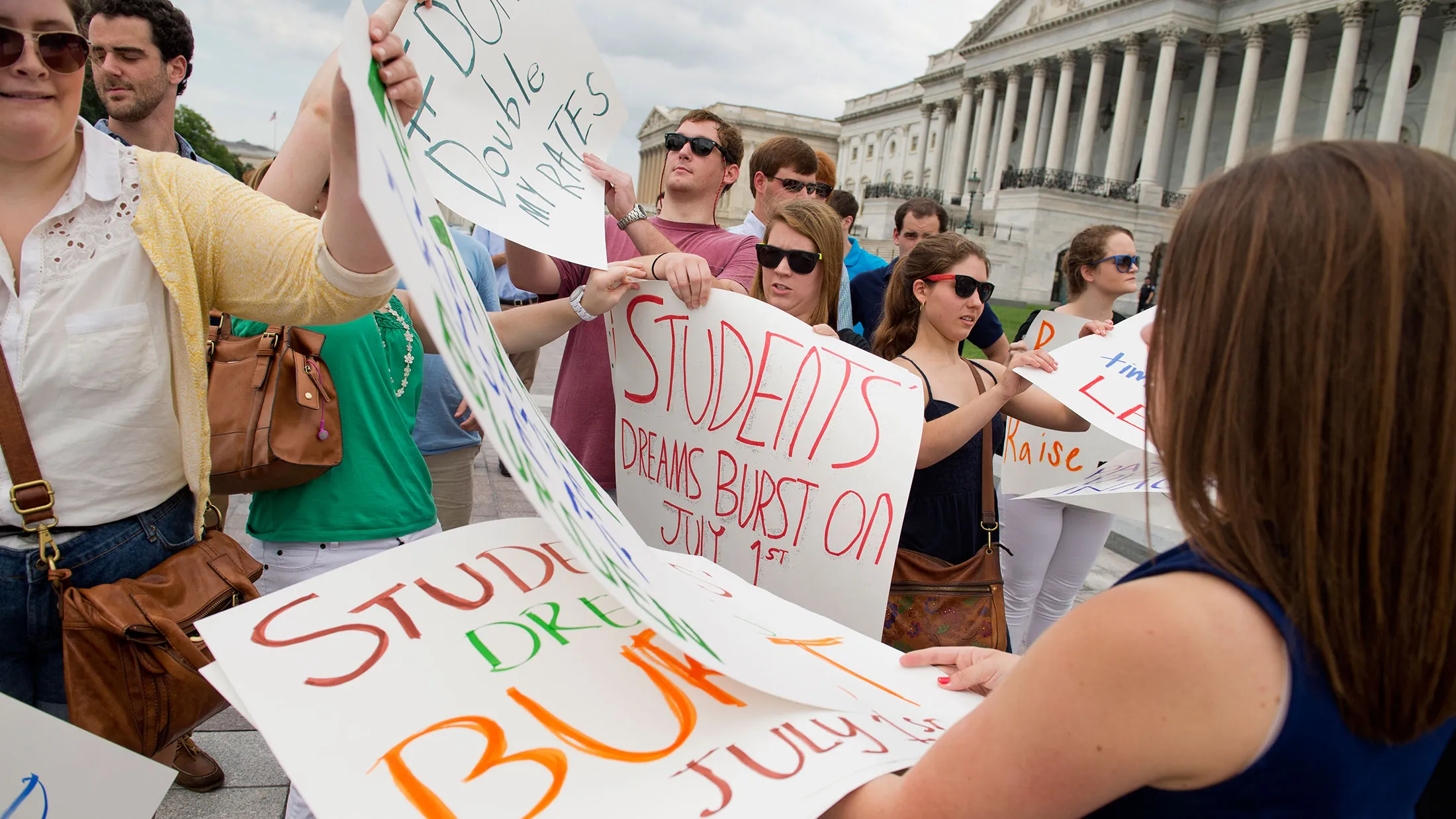 Interns from around the city gather signs before a protest on the Senate steps to urge the Senate to act on a House passed bill, Smarter Solutions for Students Act, which would prevent student loan interest rates from doubling, in this June 28, 2013 file photo.
