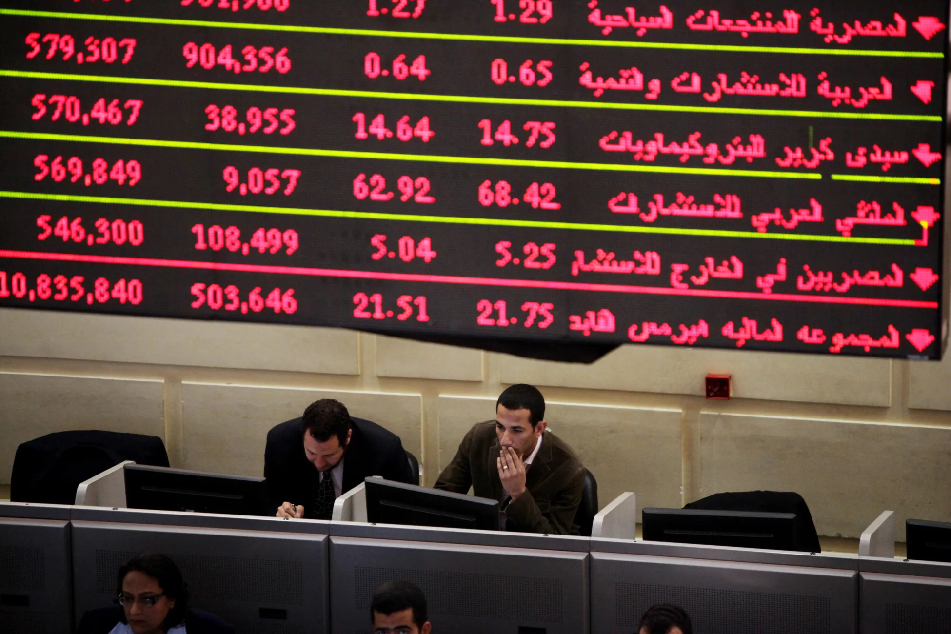 Traders sit beneath a screen at&nbsp;the Egyptian stock exchange in Cairo.