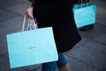 Shoppers carry Tiffany & Co. bags while walking on Fifth Avenue in New York, U.S.
