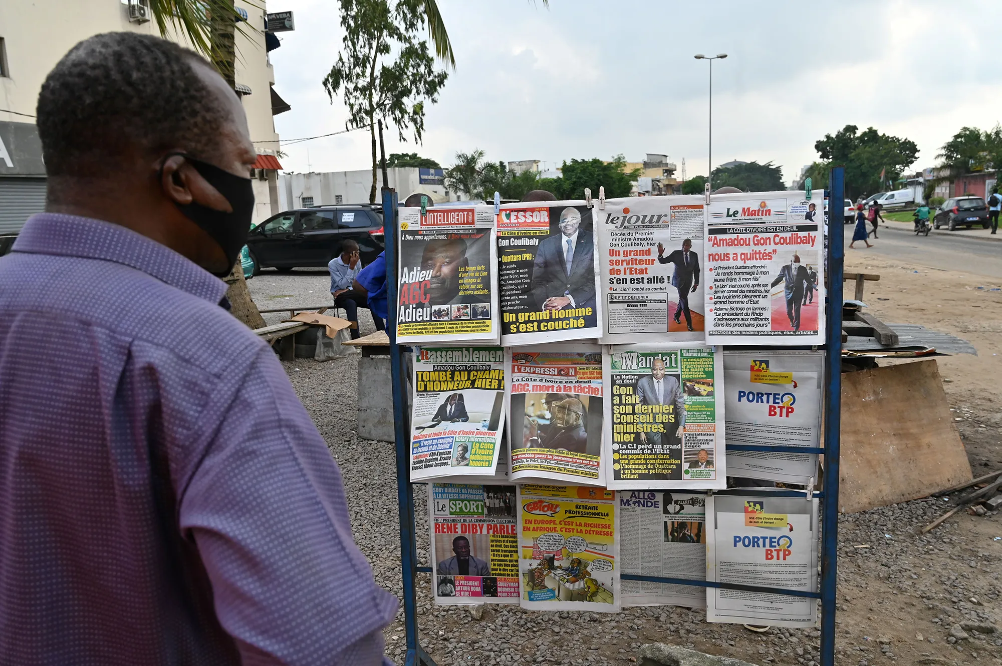 A man looks at local newspapers showing Amadou Gon Coulibaly in Abidjan on July 9.