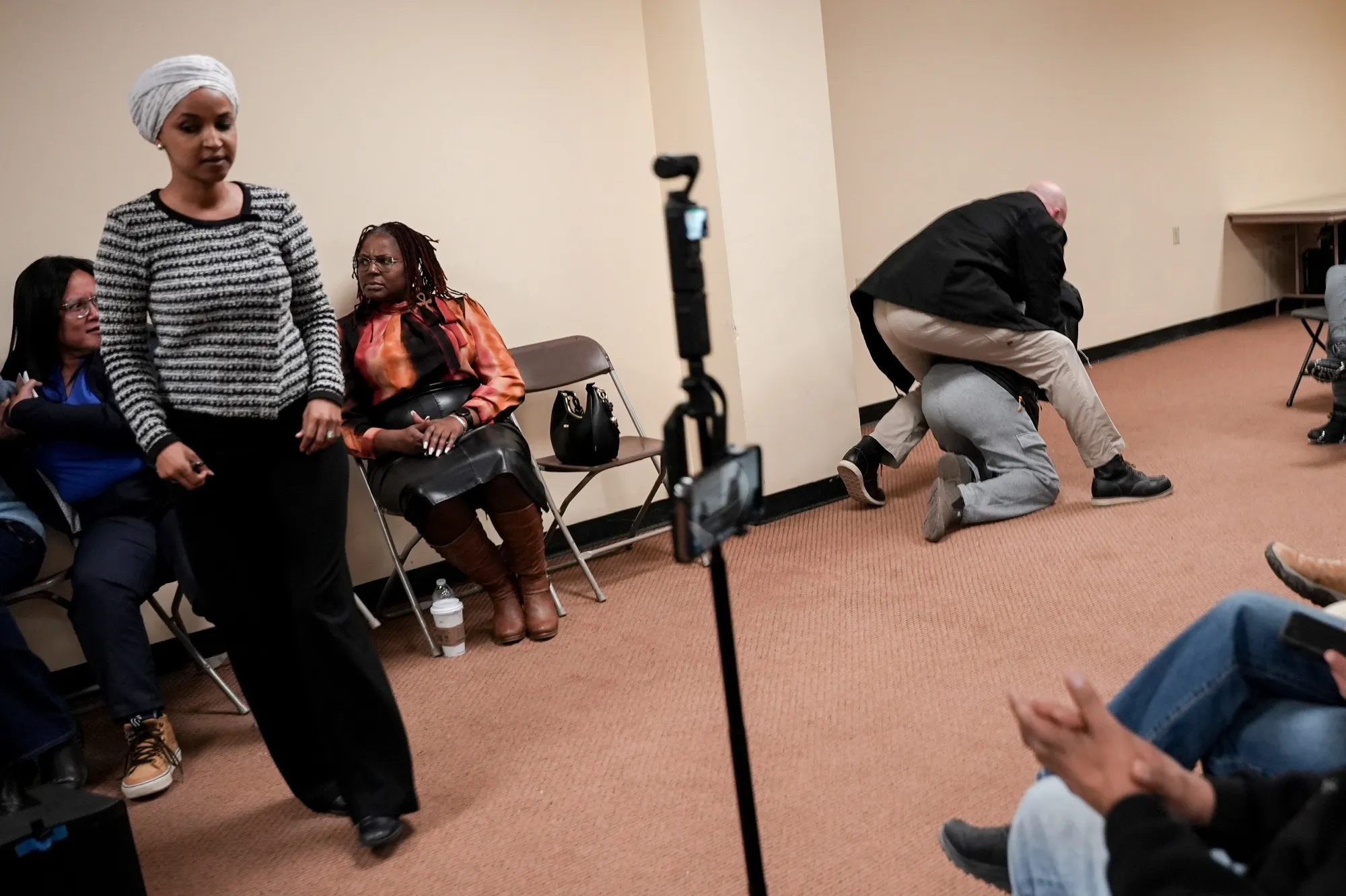 Representative Ilhan Omar, left, as a man is tackled after charging at her during a town hall event in Minneapolis on Jan. 27.