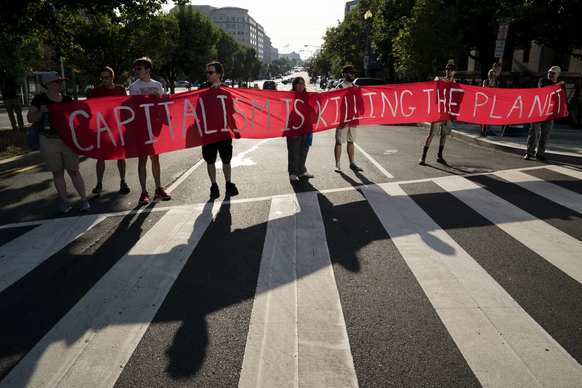 Protesters hold a sign reading "Capitalism Is Killing The Planet" during the Shut Down DC climate demonstration in Washington on Sept. 23.