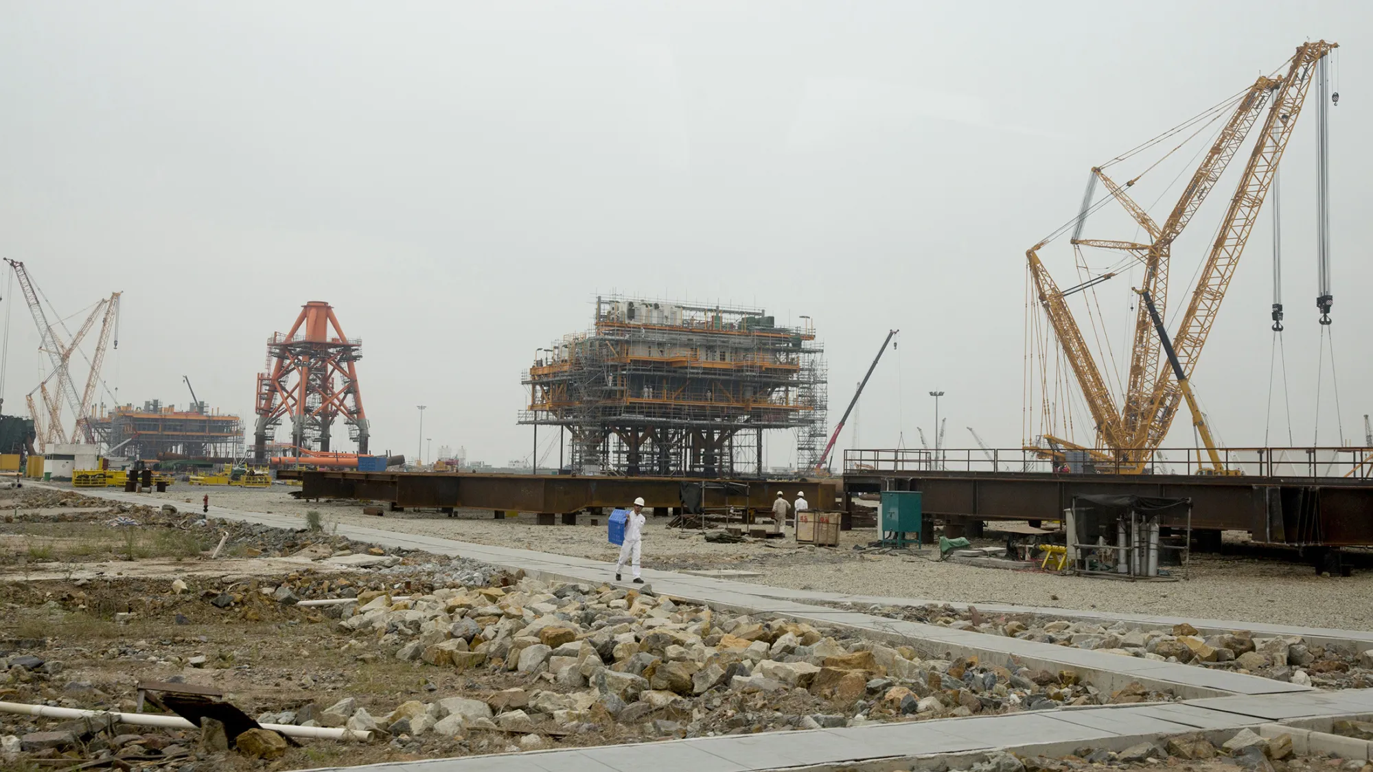 Cranes stand on a drilling platform construction site at the yard of Offshore Oil Engineering Co., a unit of CNOOC Ltd., in the Zhuhai Gaolan Port Economic Zone in Zhuhai, Guangdong province, China, on Thursday, Nov. 13, 2014. The state-owned Chinese company is looking into exploring Norway’s eastern Barents Sea, an area where licenses will be awarded in 2016.
