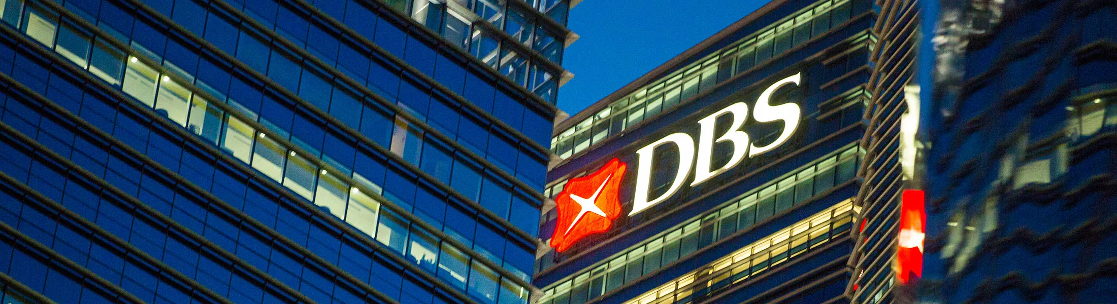 Illuminated signage is displayed on the DBS Group Holdings Ltd. bank building at night in the central business district of Singapore, on Friday, Feb. 10, 2017. DBS is scheduled to release earnings results on Feb. 14.