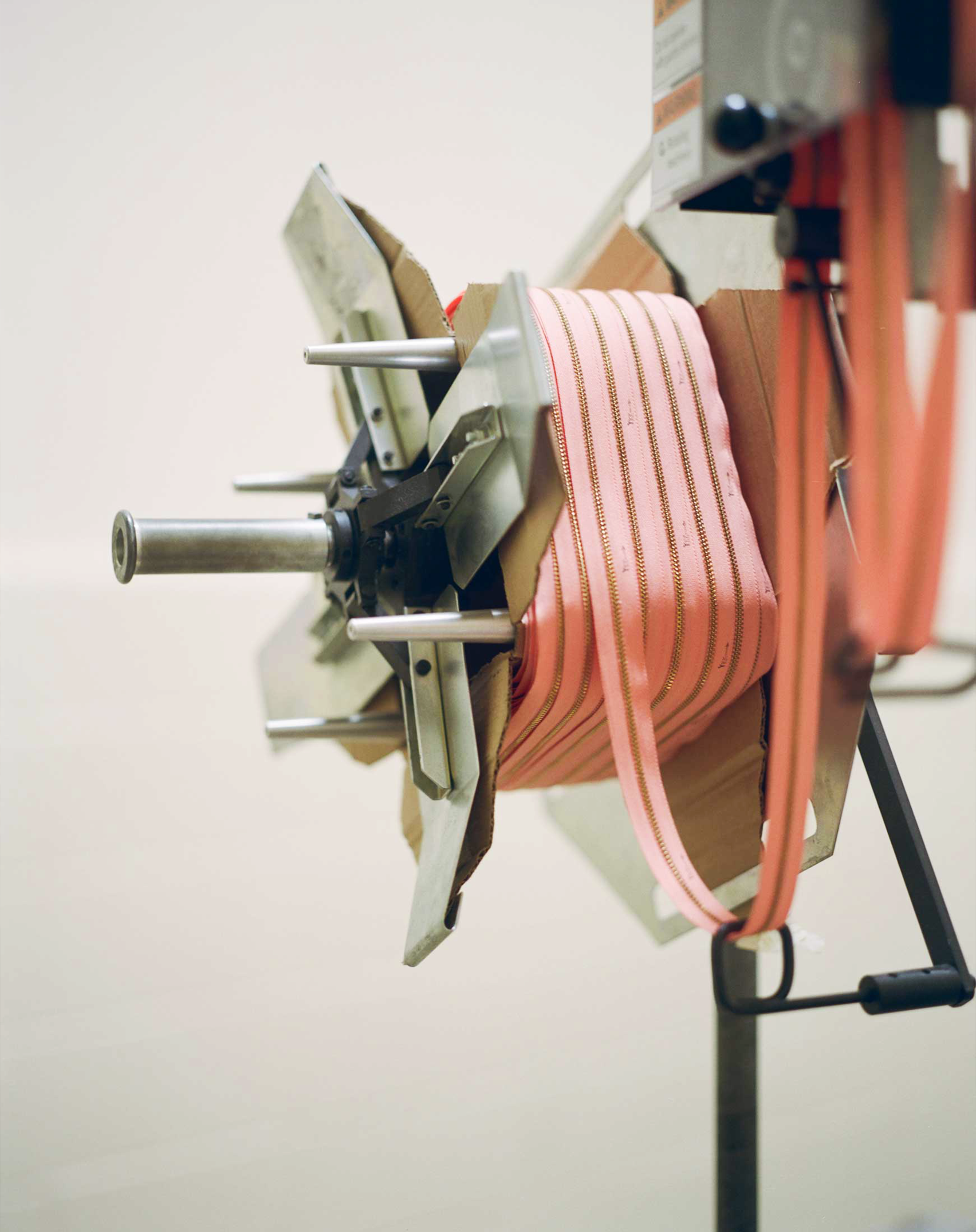 A “zipper spool holder” at YKK’s facility in Macon feeds a pink zipper into assembly.