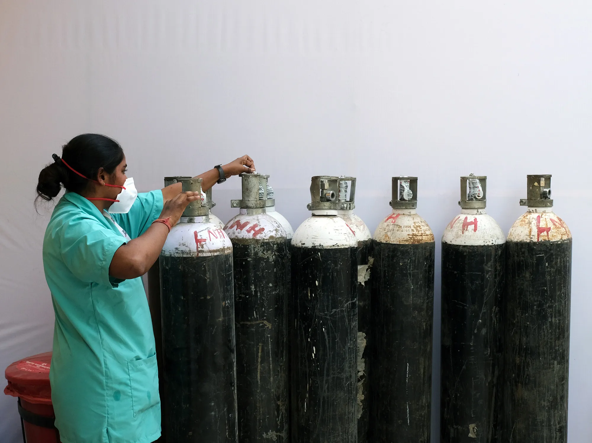 A health worker checks oxygen cylinders at a makeshift quarantine facility in New Delhi.
