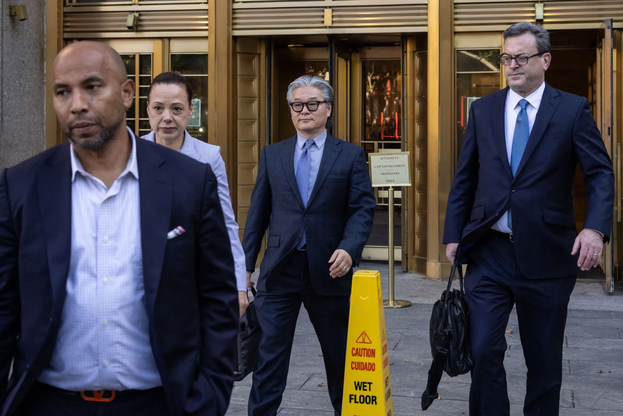 Bill Hwang, center, exits federal court in New York in July.