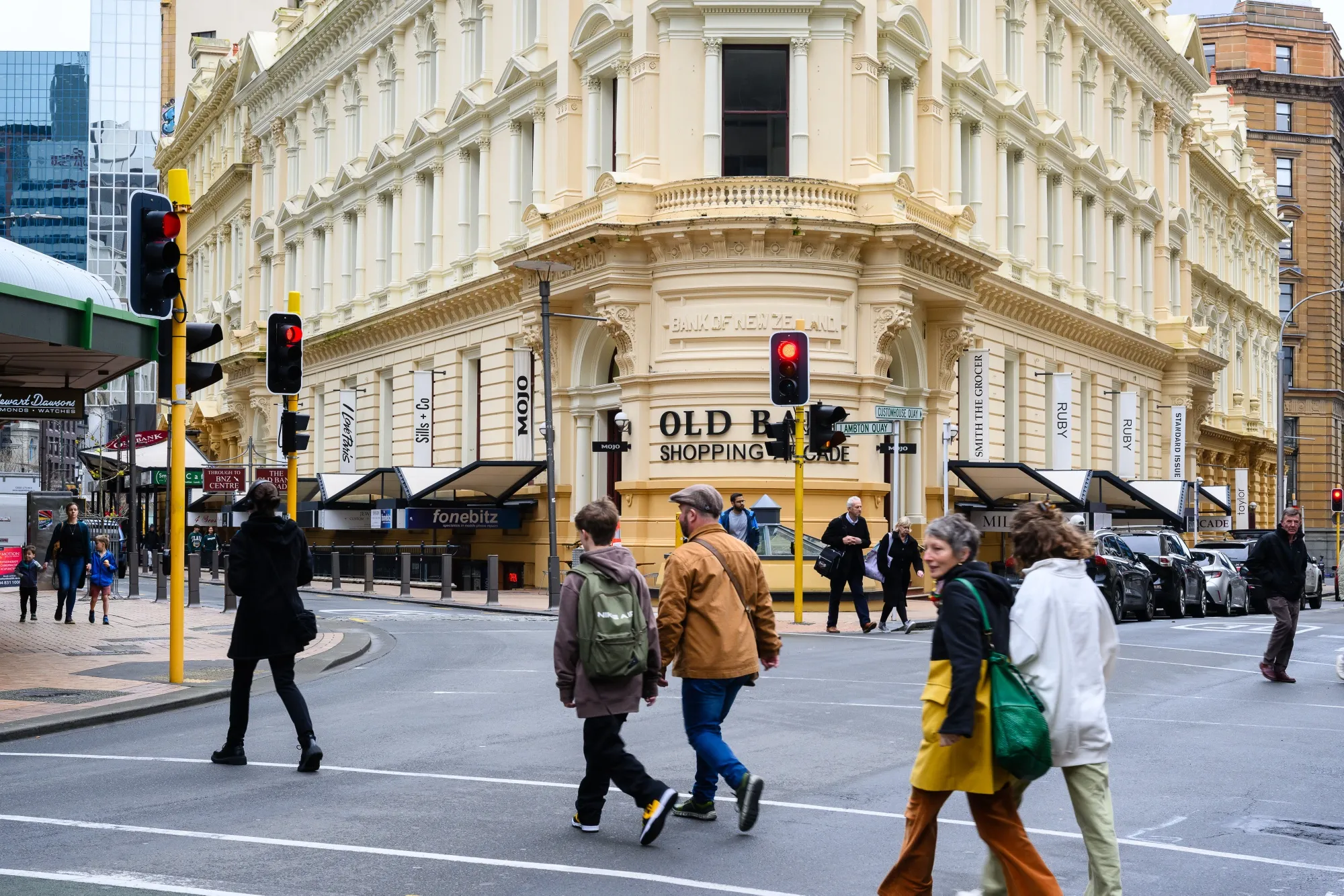Pedestrians cross a street in a shopping district in Wellington, New Zealand.