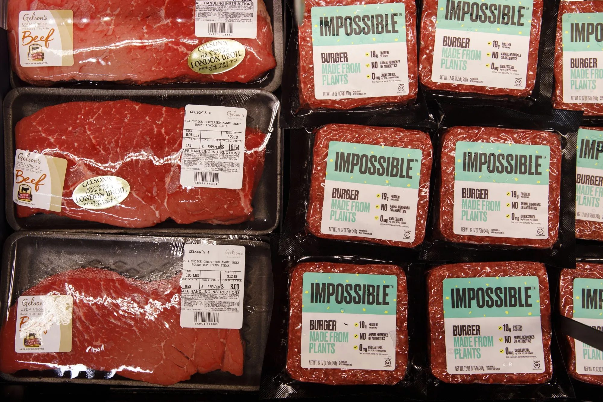 Packages of beef are displayed for sale alongside Impossible Burger plant based meat during the Impossible Foods grocery store product launch in Los Angeles,&nbsp;2019.