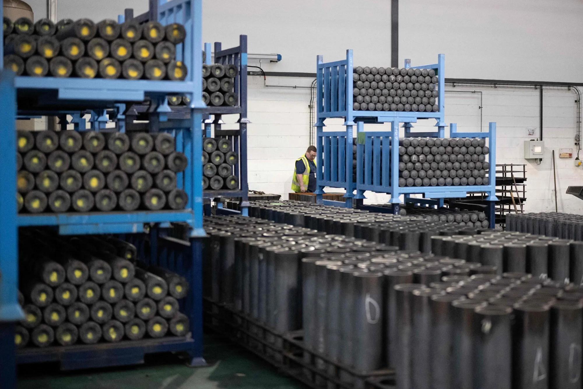 An employee inspects artillery shell casings during the&nbsp;manufacturing process at a weapons factory in Washington, England.