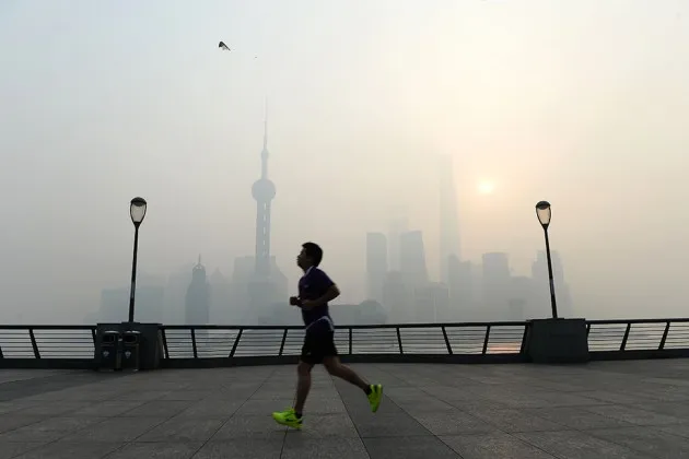 In heavy smog, a runner jogs along the promenade on the Bund in Shanghai on Nov. 12