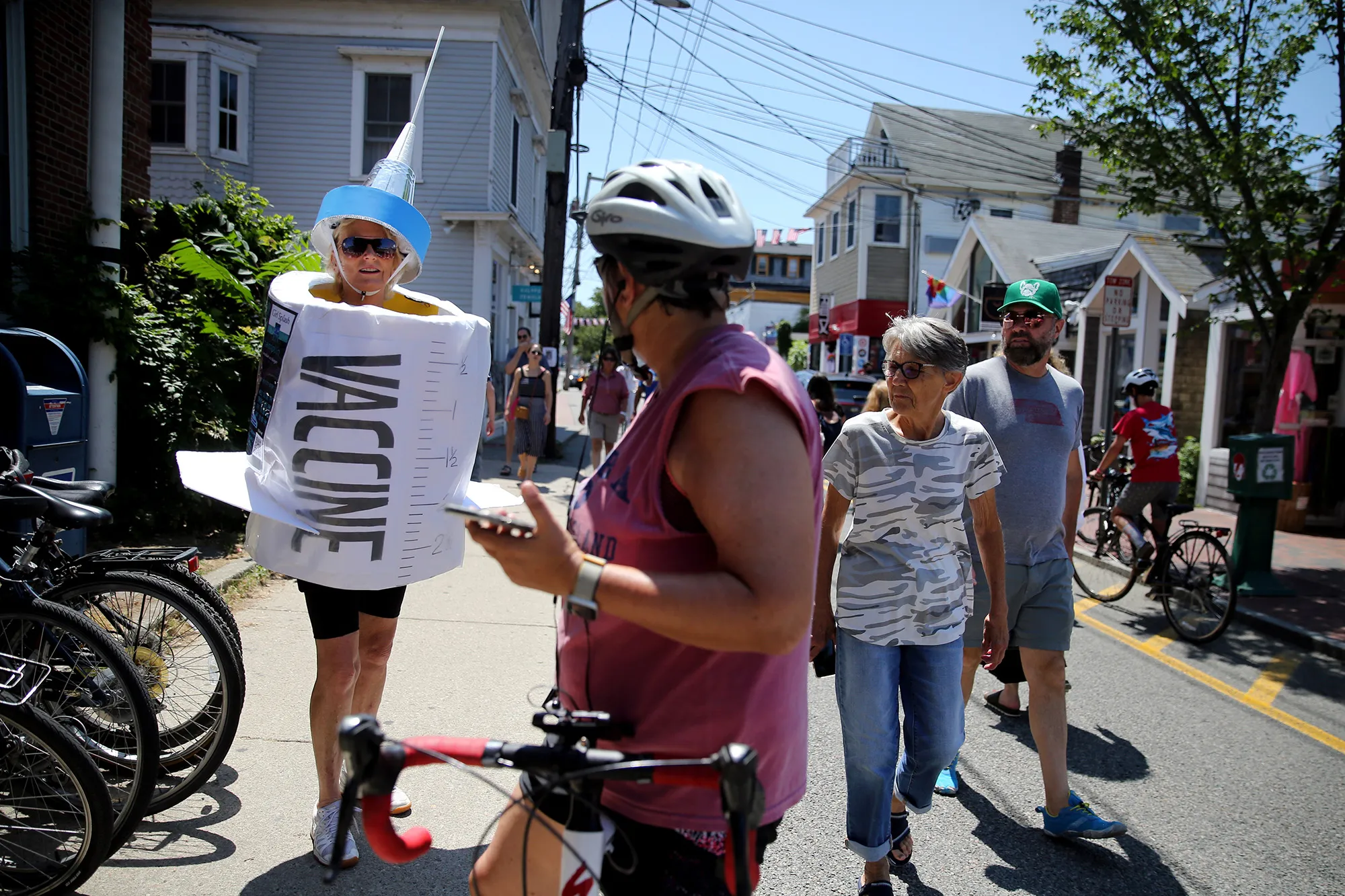 Dressed as Maxine the Vaccine, Poppy Champlin encourages pedestrians to get vaccinated while promoting her comedy show in Provincetown.