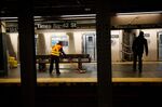 A Metropolitan Transit Authority (MTA) worker mops around a bench at a Times Square subway station in New York on April 21.