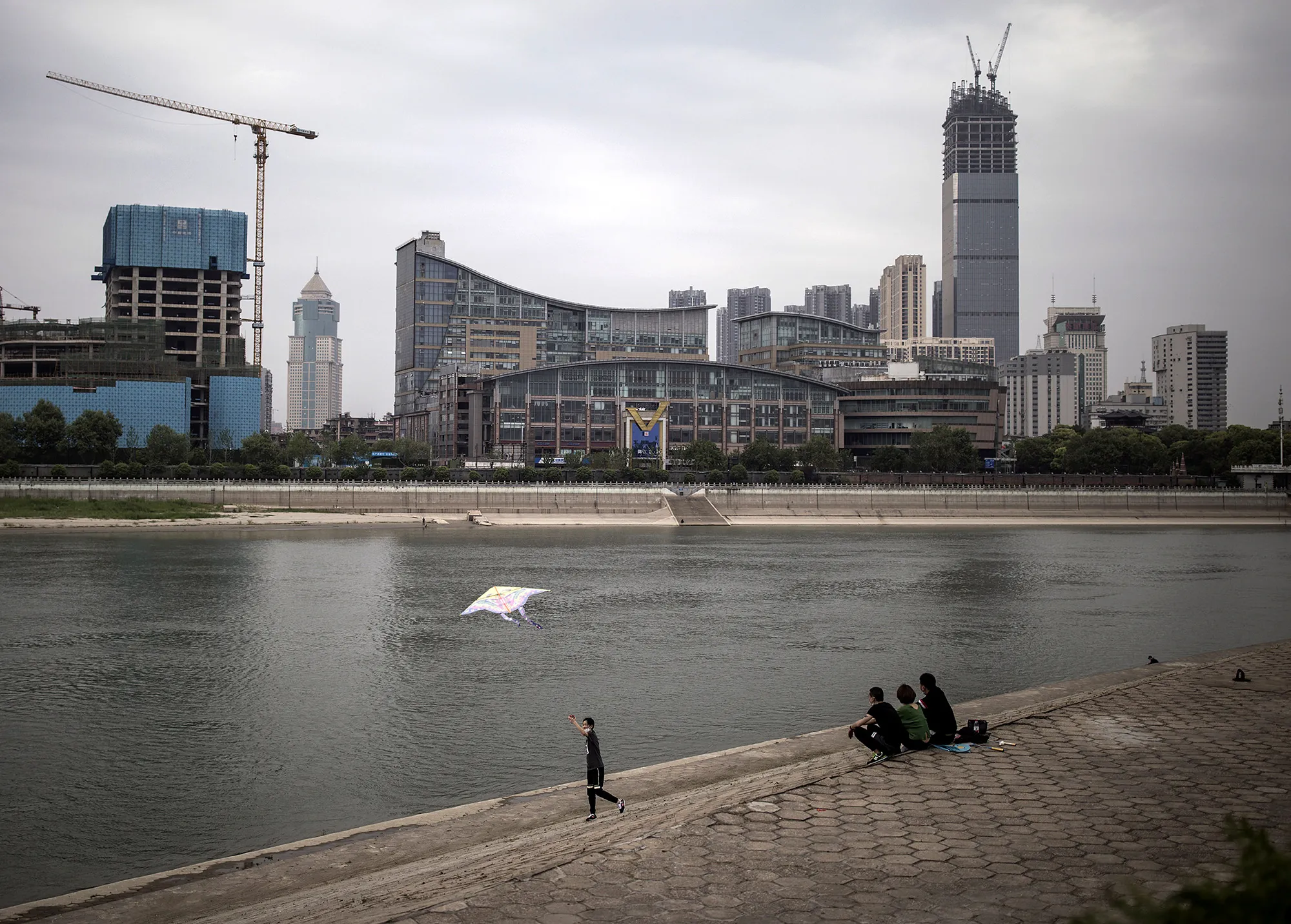 People sit by the&nbsp;Han river in Wuhan on April 17.