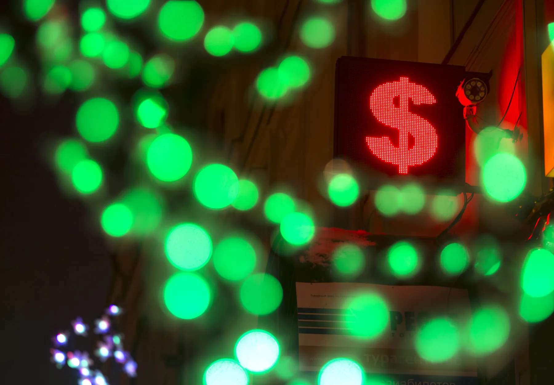 An illuminated neon electronic sign displaying a US dollar symbol hangs outside a foreign exchange bureau in Moscow, Russia.