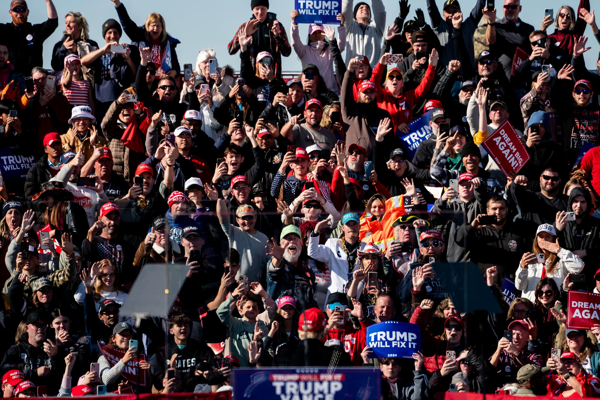 Attendees react as former US President Donald Trump, center, departs a campaign event at Fly Advanced in Lititz, Pennsylvania, US